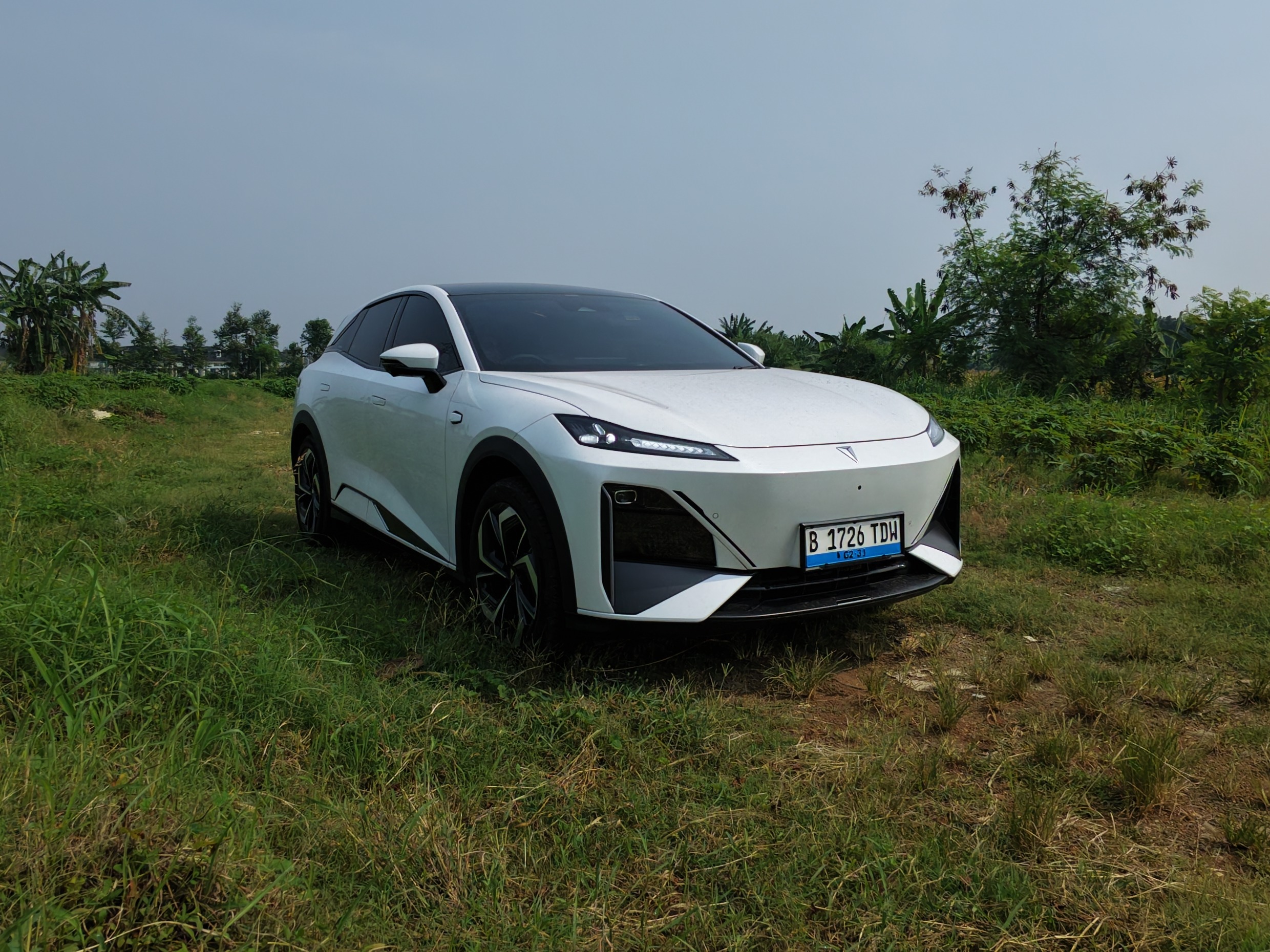 Changan Deepal S07 putih terparkir di lahan berumput, tampak depan serong